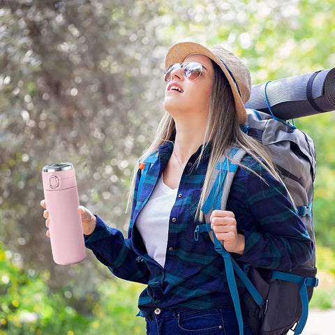 Happy woman outdoors with SteelSip Stainless Steel Thermal Bottle.