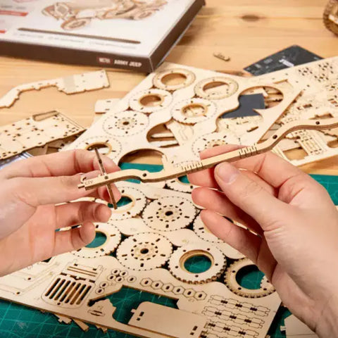 Hands assembling the Timber Express 3D Puzzle with detailed instructions.