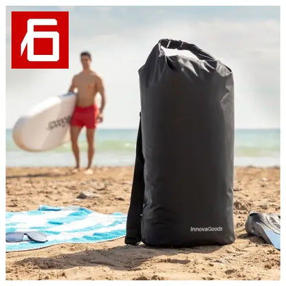 Borsa impermeabile nera su una spiaggia.