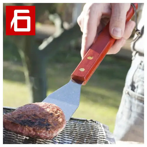 Hamburger patty flipping on grill in La Valigetta Barbecue Barbecase.